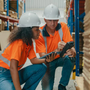Young African American black woman and caucasian man warehouse worker checks stock and check merchandise package using barcode scanner in factory warehouse. Logistic industry business. Young African American black woman and caucasian man warehouse worker checks stock and check merchandise package using barcode scanner in factory warehouse. Logistic industry business concept.